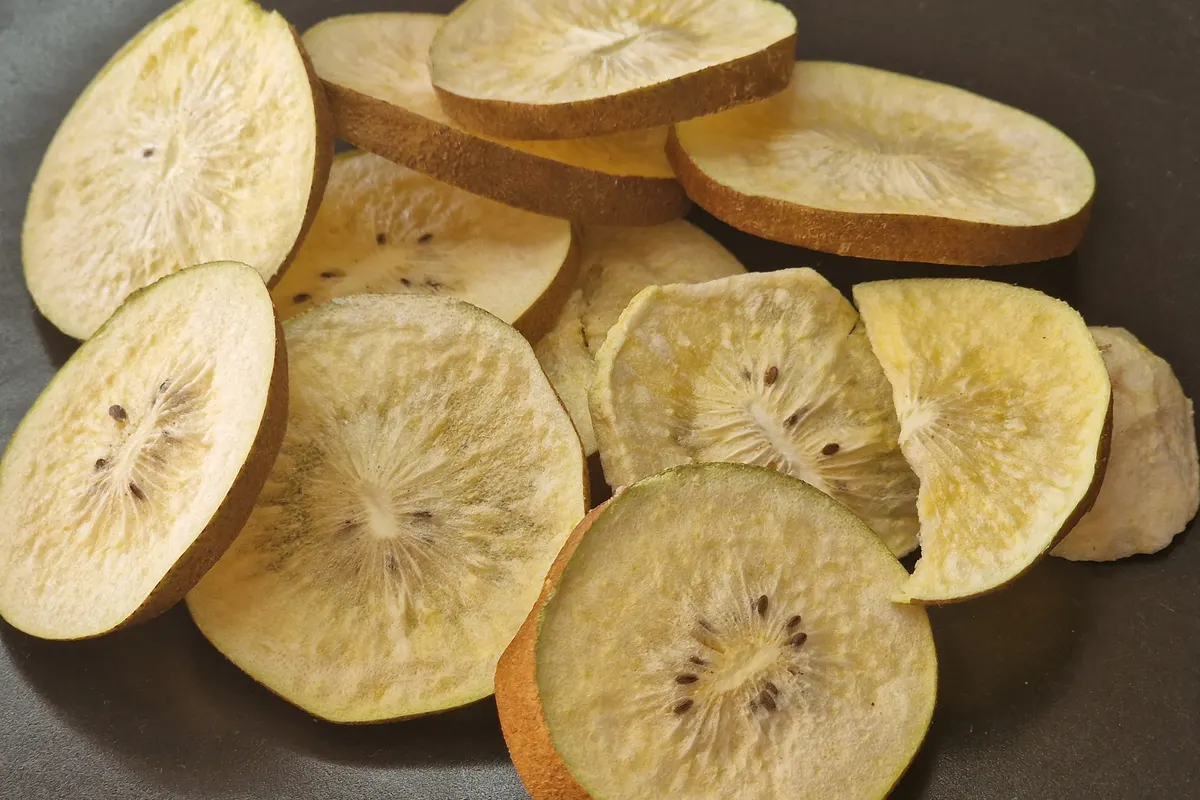 Freeze-dried kiwi slices with the skin on, seeds and core structure intact